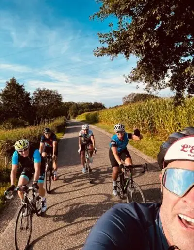 Selfie tijdens de rit met vier fietsers op een landweg langs maïsveld